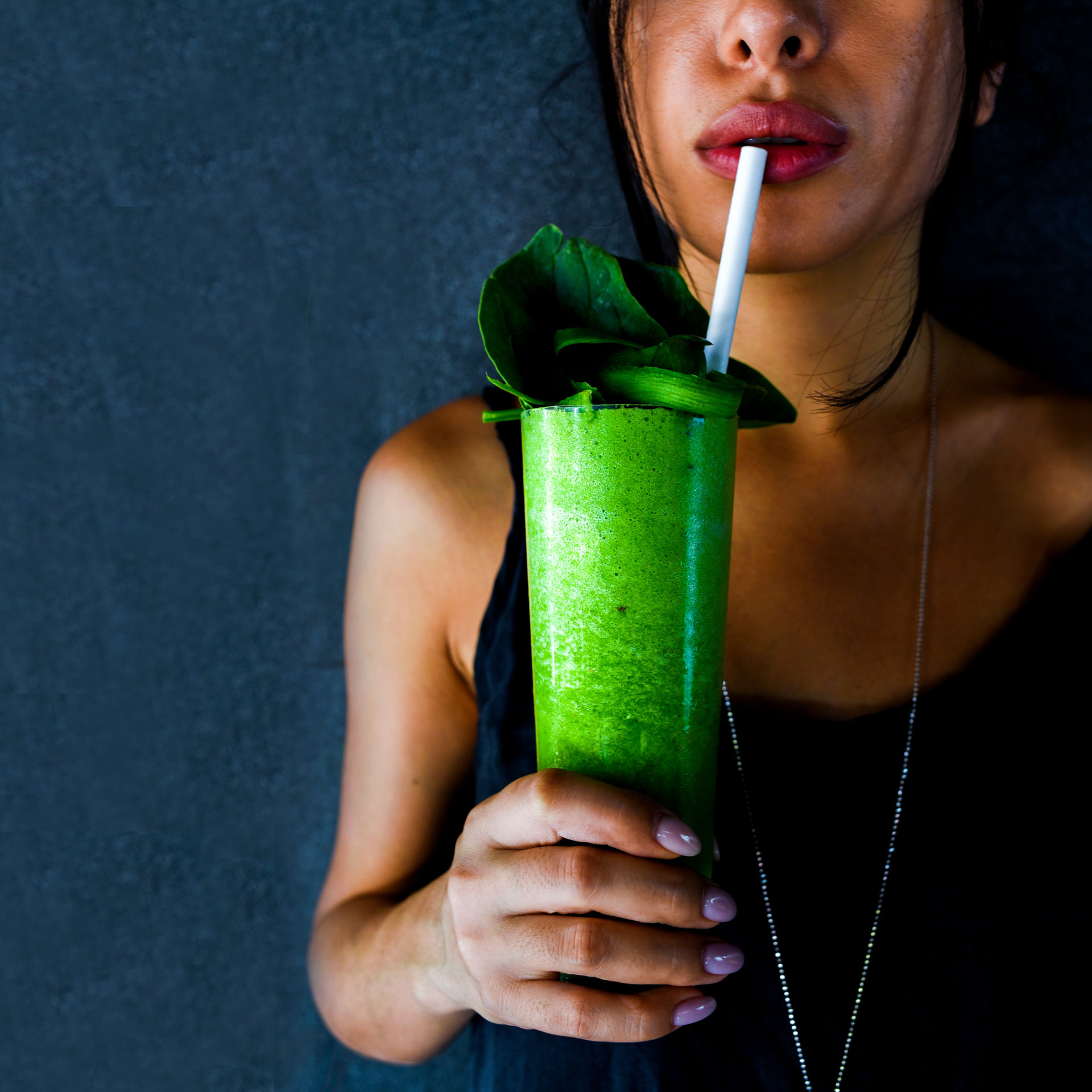 Woman drinking a fresh green vegetable smoothie
